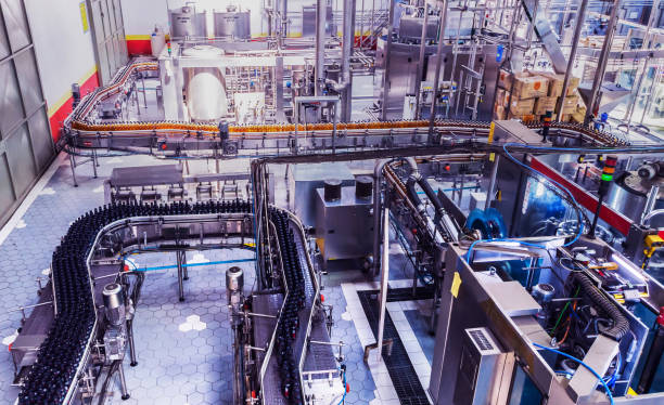 Industry, Business, Factory, Bottling Plant - Bottles Filled with Fresh Drink Moving on a Conveyor Belt to the Packaging Section of a Factory.